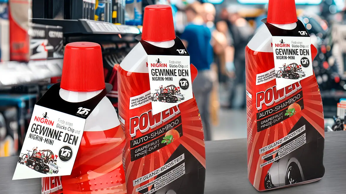 In einem Autozubehörgeschäft stehen Flaschen mit Nigrin Autoshampoo mit einen gestalteten Elastitag von L&S.