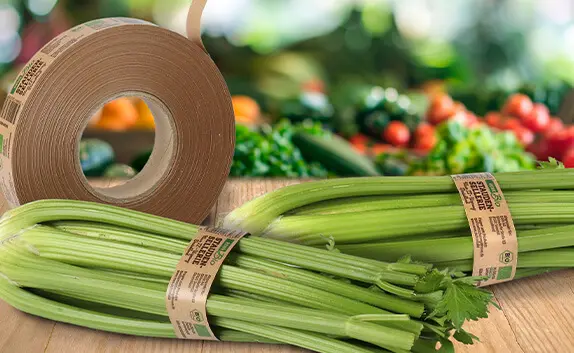 Auf einem Tisch liegt Stauden-Sellerie, der mit der LS Klebebandbanderole aus Kraftpapier gekennzeichnet ist.