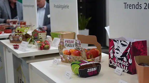Am Messestand von L&S stehen auf mehreren Podesten verschiedene Verpackungen für Obst und Gemüse.