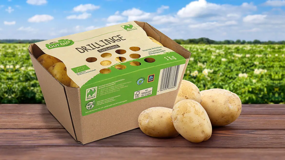 Auf einem Tisch steht eine Kartonschale für Kartoffeln